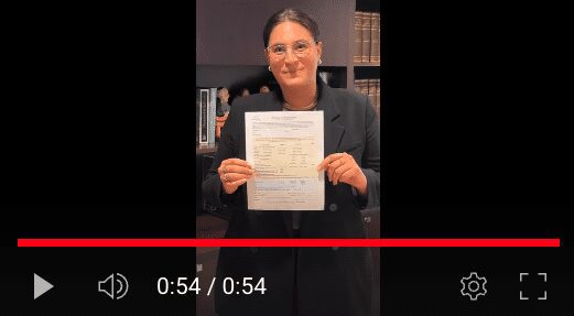A woman holding up papers in front of an image.